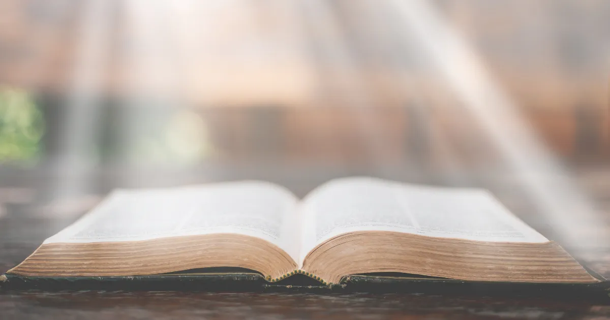 A photo comparing the Quran and the Bible side by side on a table