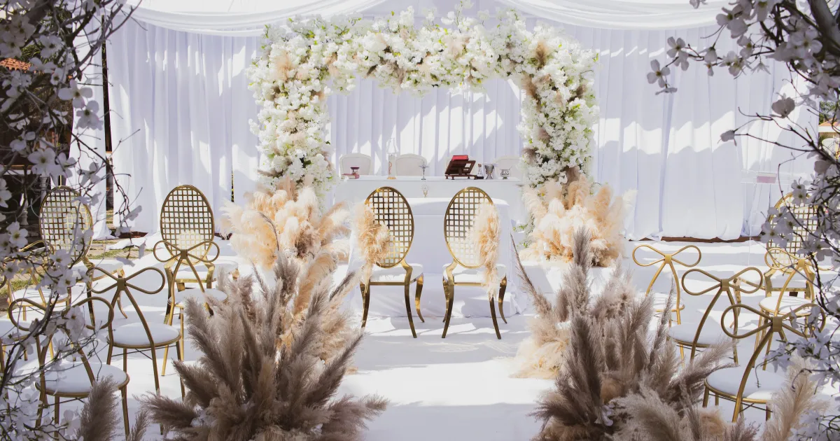 Elegant ancient Jewish wedding setting with a beautiful floral arch, golden chairs, and white drapery, symbolizing the wedding feast and Jesus returning as the Bridegroom for His bride, the Church.